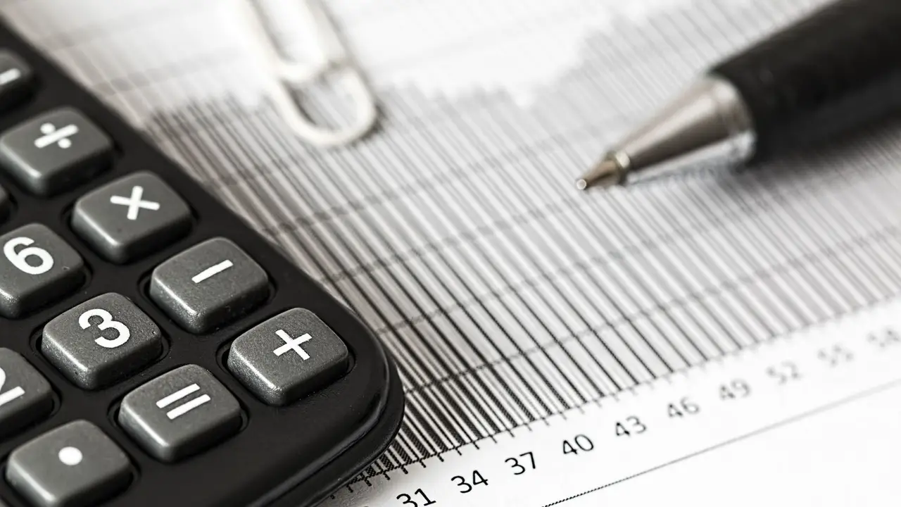 Curso de contabilidad. Calculadora y bolígrafo sobre documentos contables.