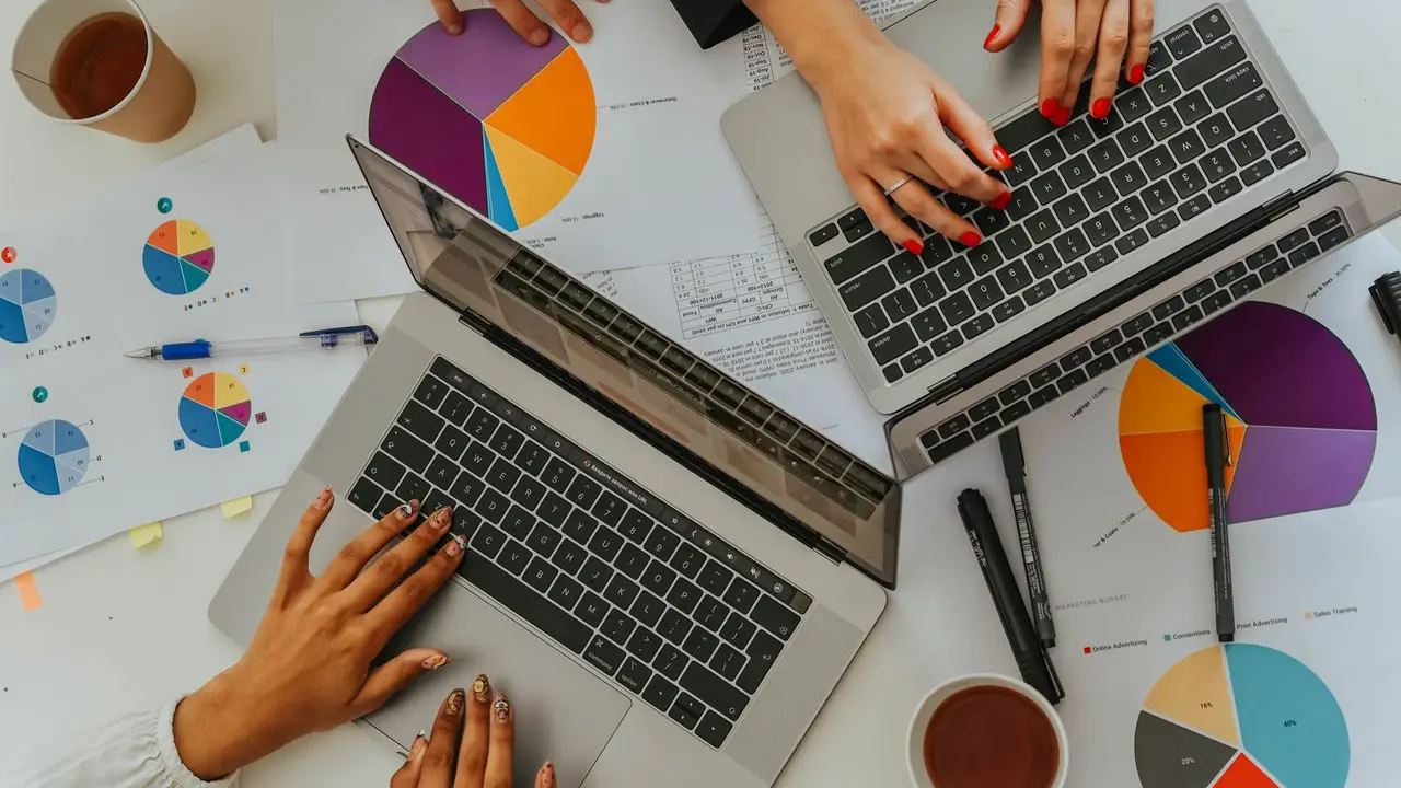Equipo de marketing analizando gráficos y campañas con portátiles.