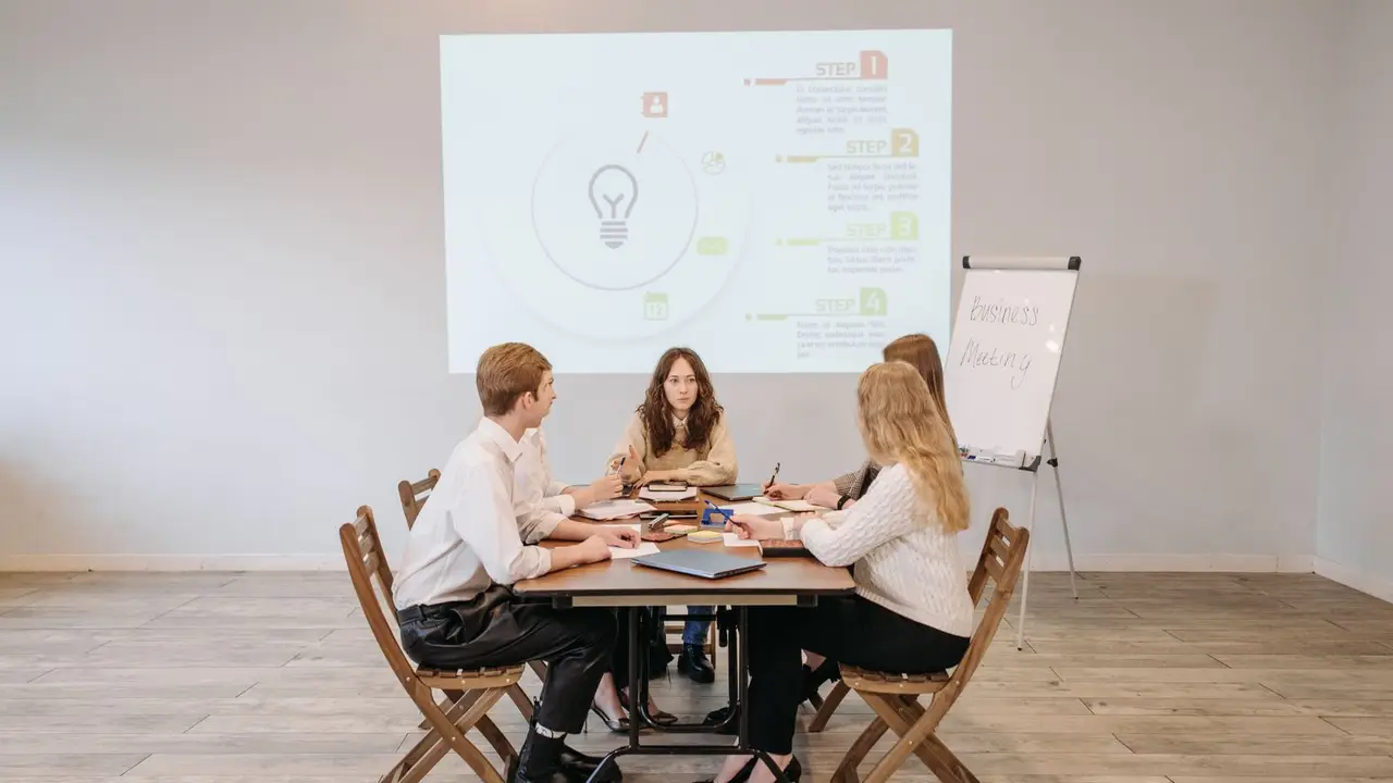 Reunión de equipo en la mesa de trabajo de una oficina.